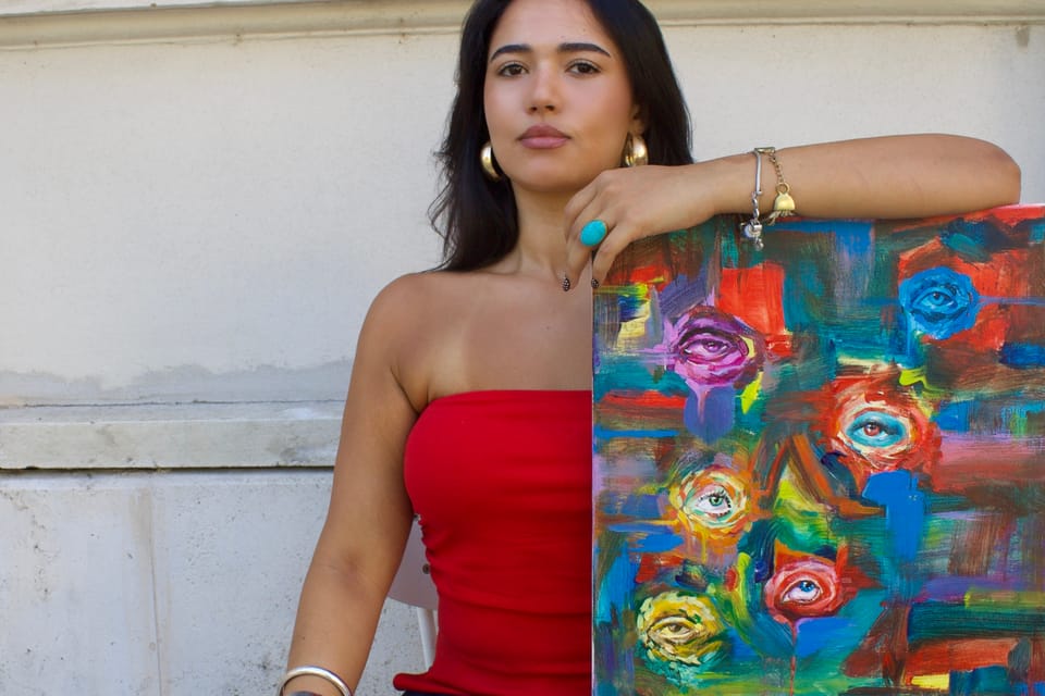 Laura Mendonzza beside her painting All Eyes on You