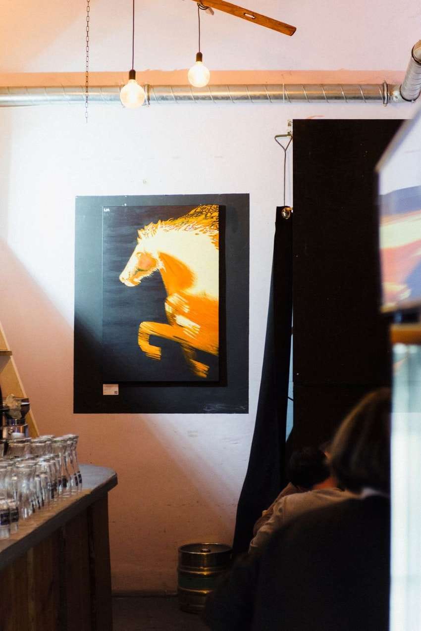 Laura's horse painting lit on a café wall